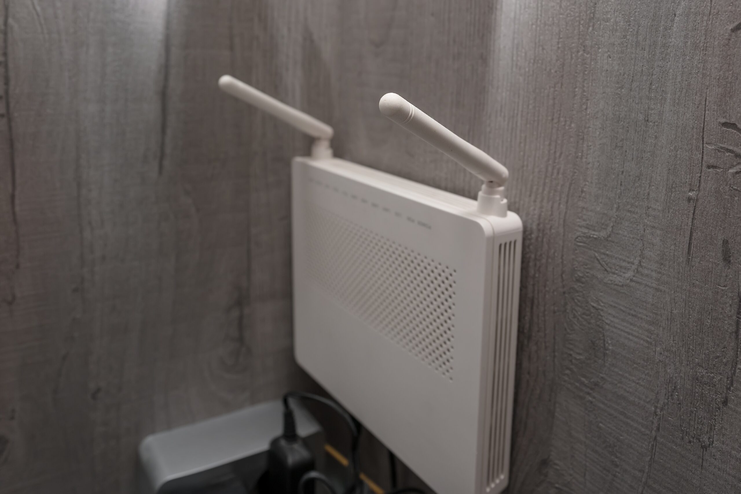 Plastic,Wifi,Router,With,Two,Antenna,Mounted,On,Wooden,Wall